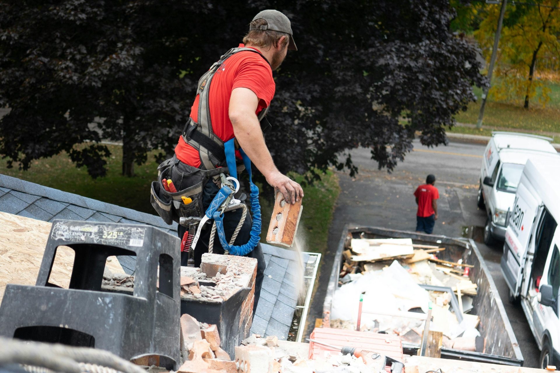 Une poubelle orange vif au couvercle bleu, située à l'extérieur d'un bâtiment urbain, illustrant le thème de la gestion des déchets en milieu urbain.